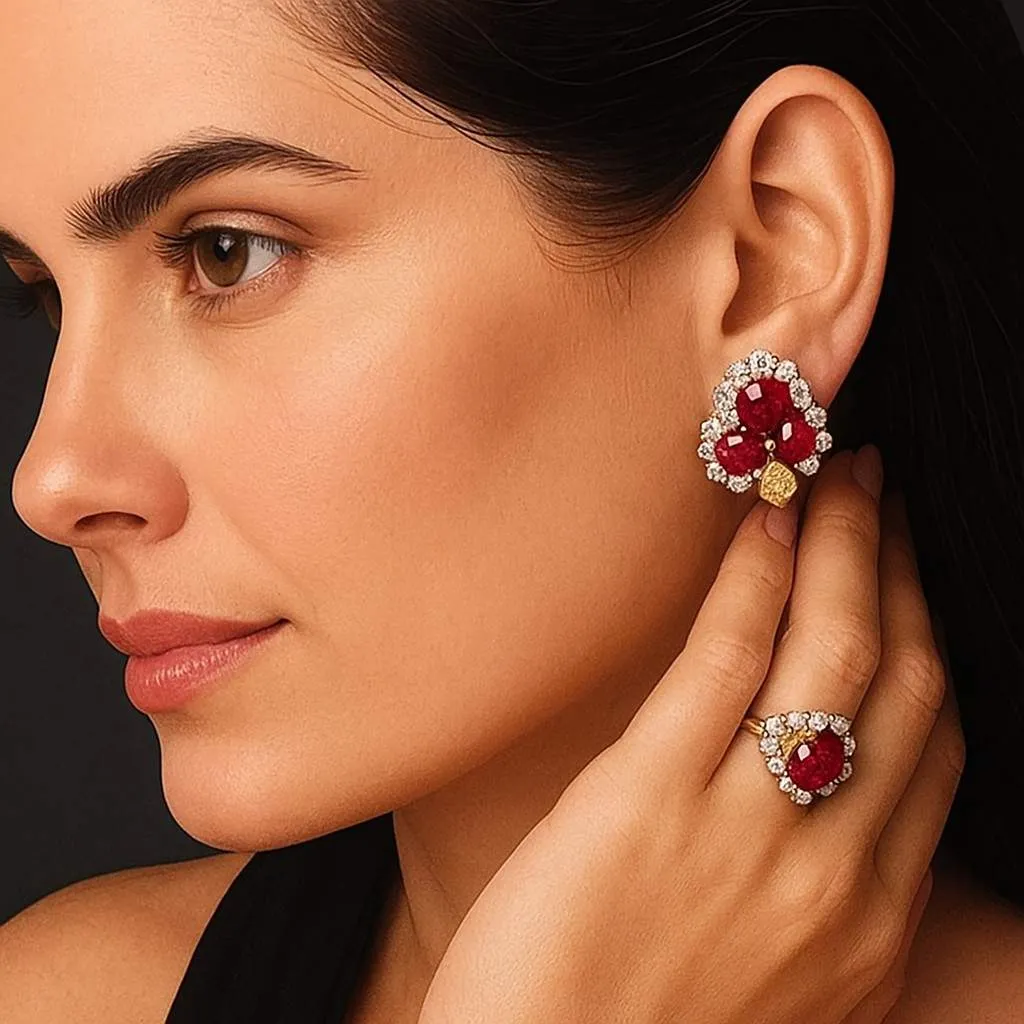 A woman dressed in a maroon outfit with lace detailing, accessorized with elaborate floral earrings featuring pearls and ruby accents. The intricate design adds a touch of luxury and traditional elegance.