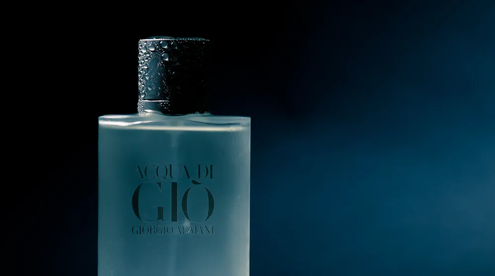 Giorgio Armani Acqua di Giò Profumo bottle near water or a beach, symbolizing freshness and timelessness.