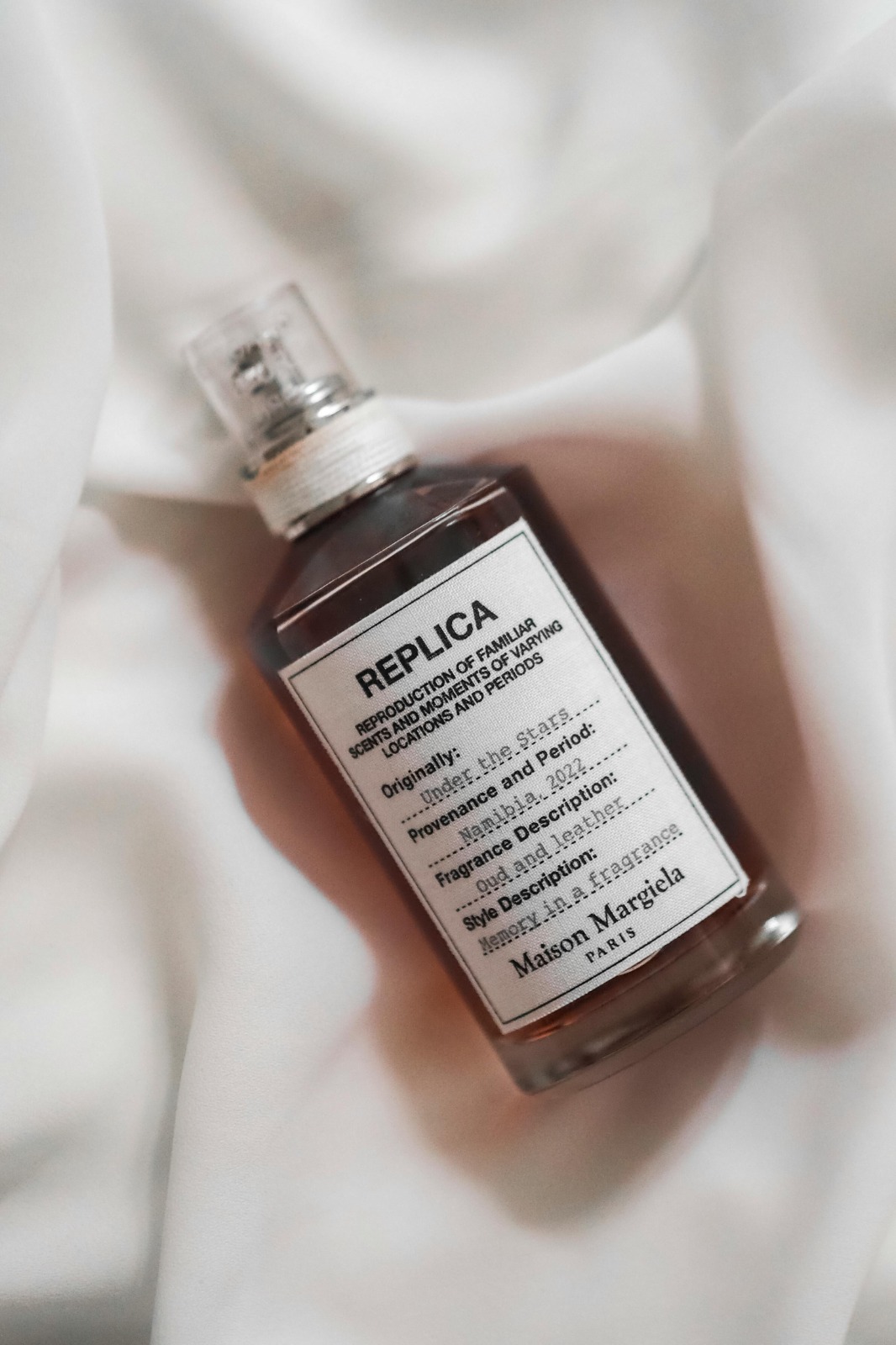 Replica By the Fireplace bottle beside a lit fireplace and roasted chestnuts, suggesting warmth and comfort.