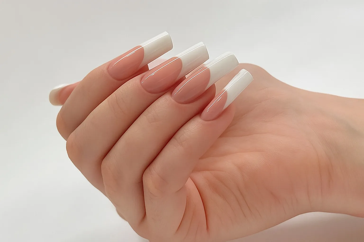 Classic French manicure with white tips and a silver glitter accent nail, captured in a cozy salon setting.