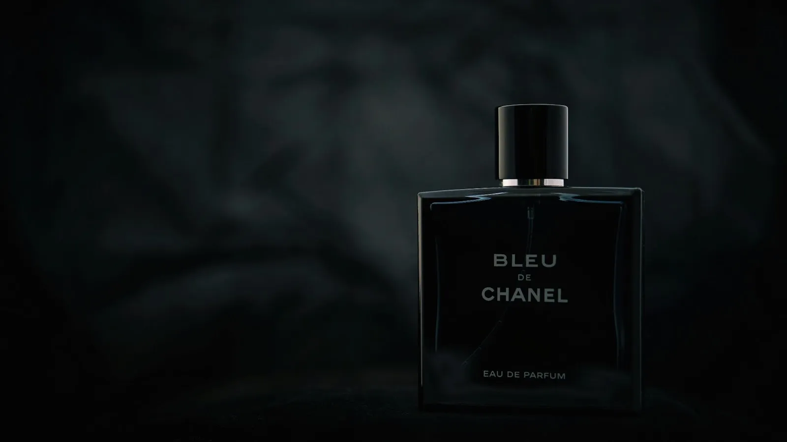 Chanel Bleu de Chanel bottle on a sleek black surface, symbolizing elegance and versatility